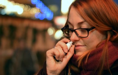 Woman using nasal spray