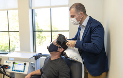 Transcranial magnetic stimulation (TMS) being performed on a patient.