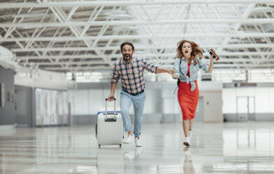 Couple running with luggage to airport gate