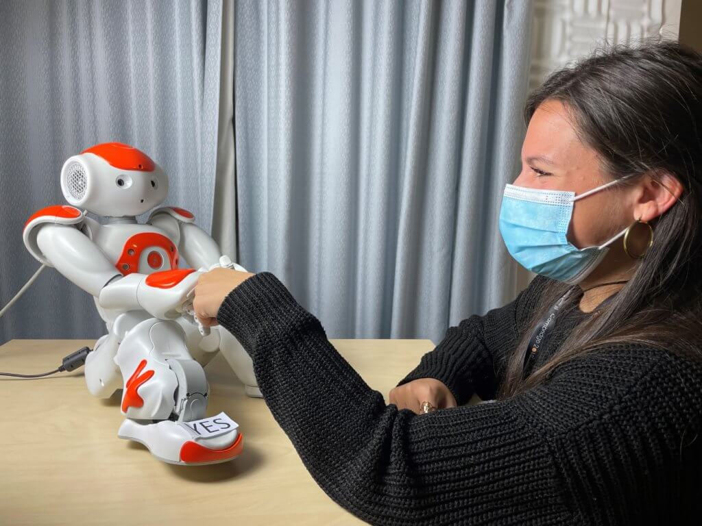 Nao robot and Dr Micol Spitale shaking hands