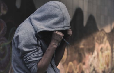 Heroin addict holding syringe